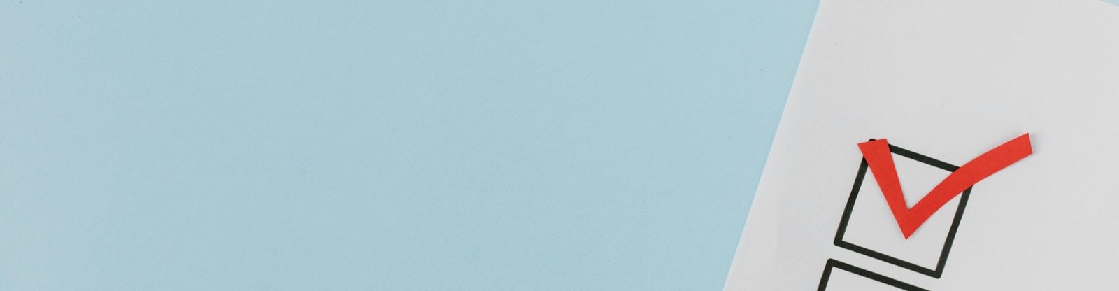 A checklist with a red checkmark symbolizing a completed task on a pastel blue background.